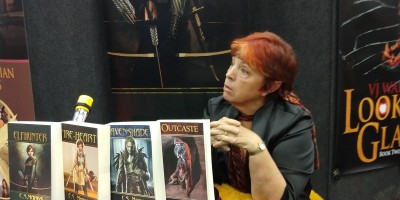 Author C.S. Marks discusses her books with prospective readers at Gen Con's Authors' Avenue